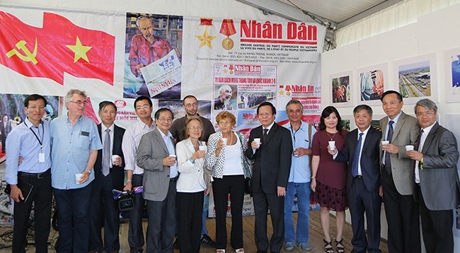 Бывший Зампредседателя Общества вьетнамцев во Франции Нгуен Тхань Тонг (5-й слева) фотографируется с делегацией газеты «Нянзан» у стенда газеты «Нянзан». 