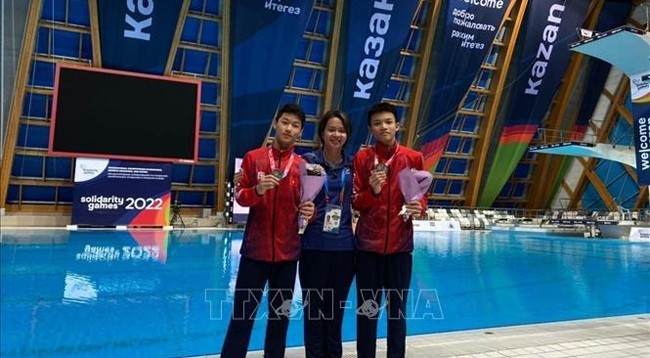 Данг Хоанг Ту (справа), Динь Ань Туан (слева) и тренер Хоанг Тхань Ча. Фото: VNA