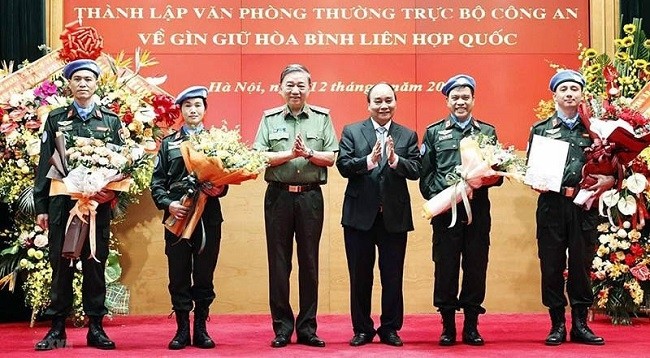 Президент Вьетнама Нгуен Суан Фук вручает решение Президента подполковнику Нгуен Нгок Хаю и цветы офицерам. Фото: VNA